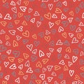 Seamless pattern with bright hand drawn hearts scattered on a red