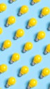 Seamless pattern of bright yellow light bulbs on a pastel blue background Royalty Free Stock Photo