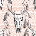 Seamless pattern with deer scull, feathers and tribal ornaments