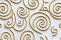 seamless pattern of delicate spirals in gold, gently rotating over a white background, creating a