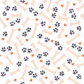 Seamless pattern design with dog paw traces, bone silhouettes and heart shapes isolated on white background.