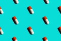 Seamless pattern diagonal rows of white and red pills in capsules with drop shadow on blue background. Healthcare Royalty Free Stock Photo