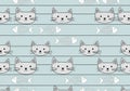 Seamless pattern featuring stylized cat faces and fish skeletons on a light blue background. The Royalty Free Stock Photo