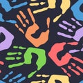 Seamless pattern with human handprints, colorful man hand stamps on dark background, vector illustration