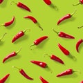 Seamless pattern made of red chili or chilli on green background. Minimal food pattern. Red hot chilli seamless peppers pattern. Royalty Free Stock Photo