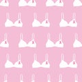 Seamless pattern with pink cancer ribbons on bras. Breast Cancer Awareness Month pink and white background. Cancer ribbon symbol. Royalty Free Stock Photo