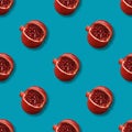 Seamless pattern with pomegranates on a blue background. Tropical abstract background. Pomegranate fruit with red shiny beads Royalty Free Stock Photo