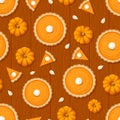 Seamless pattern with pumpkin pies and pumpkins on a wooden background. Vector illustration. Royalty Free Stock Photo