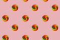 Seamless pattern of rainbow lollipop on a pink background