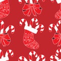 Seamless pattern red Christmas sock with various ornaments, curls and swirls on a dark red background. In sock Christmas candy Royalty Free Stock Photo