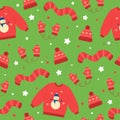 Seamless pattern of red winter hat, mittens, scarf and sweater. Winter elements on green background. Doodle style. Royalty Free Stock Photo