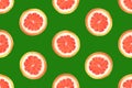 Seamless pattern from round slices of ripe juicy pink grapefruit on green background