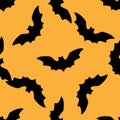 Seamless pattern silhouette of a black bat on an orange background for a Halloween design template. The pattern of a soaring bat Royalty Free Stock Photo