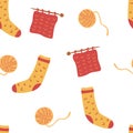 Seamless pattern with socks and knitting. Ball of thread, knitting needles and socks. Cute winter or autumn cozy background for