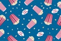 Seamless pattern with striped popcorn box, popcorn grains on a blue background. Movie junk food. Vector illustration Royalty Free Stock Photo