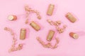 A seamless pattern or wallpaper made of golden wine corks and golden ribbons on pink background. Creative concept for Valentine`s