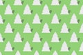 Seamless pattern of white clay Christmas tree toys in the form of Christmas trees on green background.