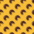 Seamless pattern wiht bitten glazed chocolate donuts, yellow background. Confectionery banner