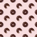 Seamless pattern wiht whole and bitten glazed chocolate donuts, pink background. Creative confectionery banner. Pastel colors Royalty Free Stock Photo