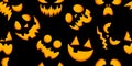 Seamless pattern of yellow jack lantern faces on black background. Halloween design Royalty Free Stock Photo