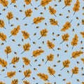 Seamless pattern with yellow oak leaves and acorns on blue background. Autumn concept Royalty Free Stock Photo