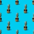 Seamless pineapple pattern in sunglasses highlighted on a blue background. Trendy hipster pineapple fruit with Royalty Free Stock Photo