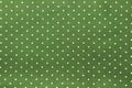 Seamless polka dots pattern on green fabric