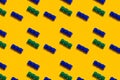 Seamless regular pattern with blocks from the children`s constructor on a yellow background. Father and childhood day holiday Royalty Free Stock Photo
