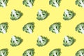 Seamless regular pattern of broccoli slices on bright yellow background.