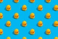 Seamless regular pattern with yellow ducks on a blue background. The concept of games in the bathroom and summer vacation