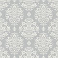 Seamless repeating pattern featuring elegant white baroque damask motifs intricately overlaid upon a subtle light gray textured Royalty Free Stock Photo