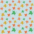 Seamless repeating pattern of multicolored maple leaves on a blue background. Royalty Free Stock Photo