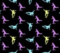 Seamless skateboarding pattern with multi-colored silhouettes of skateboarders on black background