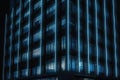 Seamless skyscraper facade with blue tinted windows and blinds at night. Royalty Free Stock Photo