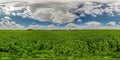 Seamless spherical hdri 360 panorama among green farming fields in summer day with awesome clouds in blue sky in equirectangular Royalty Free Stock Photo