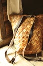 Seamless splint backpack on the floor leaning on the wall. Handmade weaved rustic backpack with leather straps