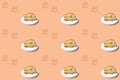 Seamless texture, pattern with piece of biscuit cake with chocolate, cream, marzipan on white plate, isolated peach background, Royalty Free Stock Photo