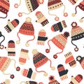 Seamless vector background with hats and mittens. Pattern tile with knitted winter clothes in red and blue. Winter wear design, Royalty Free Stock Photo