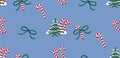 Seamless vector pattern with candy canes, ribbon bows and winter fir trees on a blue background. Flat style decorative design for Royalty Free Stock Photo