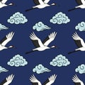 Seamless vector pattern of red-crowned cranes flying through stylized clouds on a dark blue background Royalty Free Stock Photo