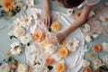 A seamstress girl decorates a dress with flowers, top view