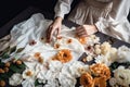 A seamstress girl decorates a piece of fabric with delicate flowers, top view