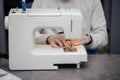 seamstress girl works, sews clothes on a sewing machine, hands close-up. The process of sewing in an atelier or workshop Royalty Free Stock Photo