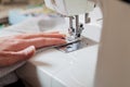 Seamstress hand guides seam on modern sewing machine Royalty Free Stock Photo