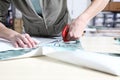 Seamstress hands cutting the fabric with scissors