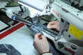 Seamstress hands sew on a pro electrical sewing machine. Parts of sewing machine needle bar, presser foot, needle plate