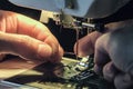 Seamstress inserts the thread through the needle threader of the sewing machine Royalty Free Stock Photo