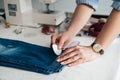 Seamstress marking hem on a pair of jeans