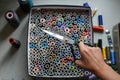 A seamstress pulls a pair of scissors out of a box with skeins of colored threads.Sewing industry