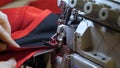 A seamstress in a seamstress factory at home sews clothes from fabric materials. Using a sewing machine in slow motion. Concept